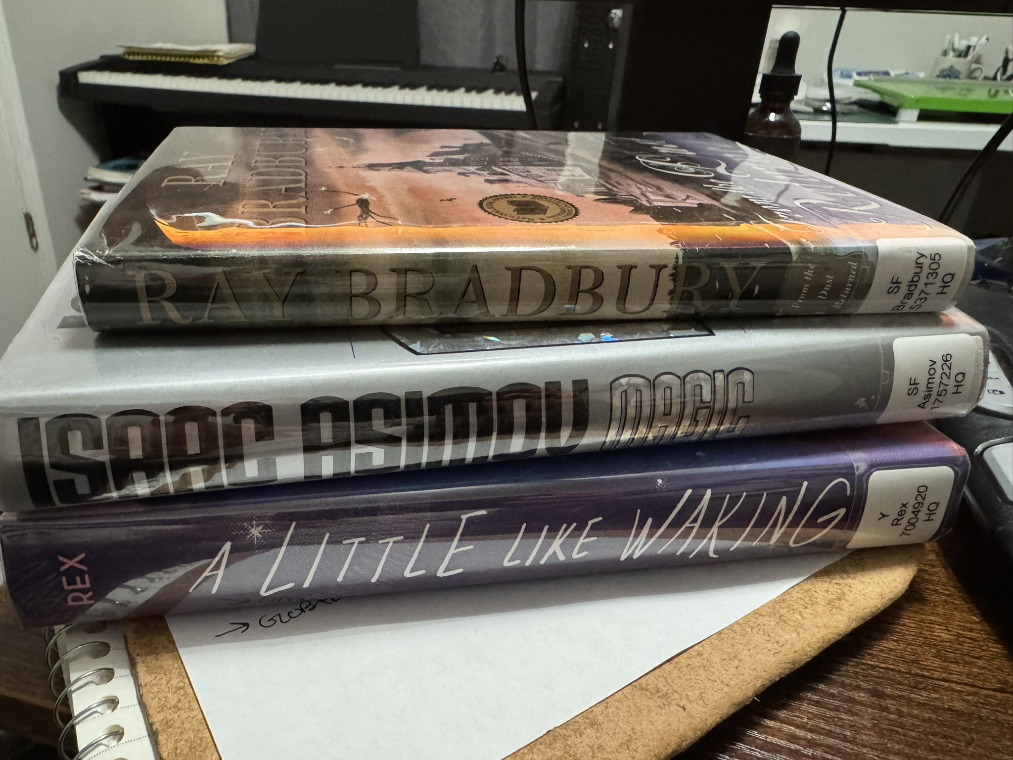 Three library books stacked on one another, ready to be red.